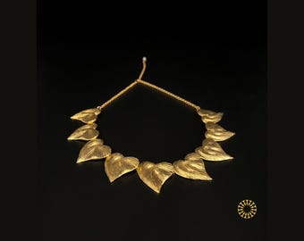 Elevate your collection with this striking statement piece. This necklace features a series of sculpted leaf charms from lightweight brass.