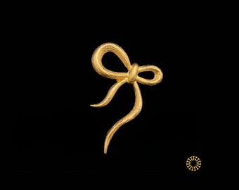 This elegant piece features a hand-sculpted aesthetic, capturing the fluid motion of a tied ribbon. It adds an elegant to your style.