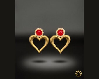 This overall look is one of minimalist luxury. Each stud features red cabochon center, encircled by a halo of clear crystals.