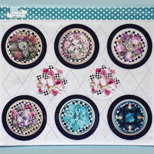 May include: Set of seven round decorative paper stickers with black and white checkered borders. The stickers feature floral and geometric designs in shades of pink, blue, green, and gold.