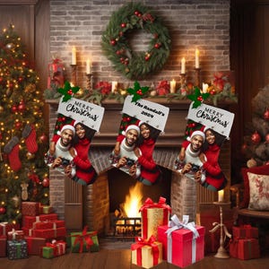 May include: Three personalized Christmas stockings hang above a fireplace. Each stocking features a photo of a couple, with the text "Merry Christmas" or "The Randall's 2024". The scene includes a Christmas tree, gifts, and a wreath.