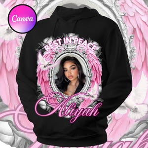 May include: Black hoodie with a memorial design. The design features a portrait of a woman within a decorative frame, surrounded by pink wings and the words "Rest in Peace" and "Aaliyah". The top of the image reads "Memorial Design Template".