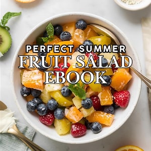 May include: A vibrant fruit salad in a bowl, featuring blueberries, raspberries, and orange segments. The image includes the text "PERFECT SUMMER FRUIT SALAD EBOOK". A spoon is in the bowl, and a half orange is visible.