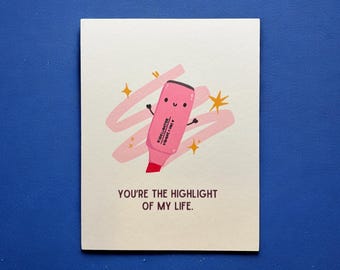 May include: A greeting card with a pink highlighter illustration and the text "You're the highlight of my life." The highlighter has a smiling face and arms, with a pink swish and gold star accents.