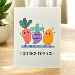 May include: A greeting card with a cartoon carrot, turnip, and potato with smiling faces and the text "ROOTING FOR YOU!"