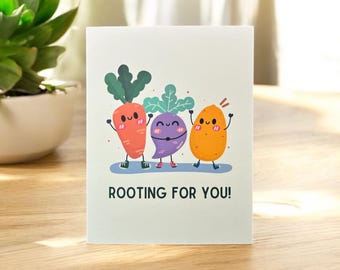 May include: A greeting card with a cartoon carrot, turnip, and potato with smiling faces and the text "ROOTING FOR YOU!"