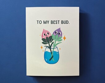 May include: A greeting card with a light pink and purple flower illustration in a blue vase. The card says "To my best bud."