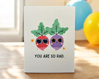 May include: A greeting card with two cartoon radishes wearing sunglasses. The radishes are red and purple and have happy faces. The card says "You are so rad."