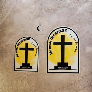 May include: Two yellow and black stickers with a cross and the text "He must increase, I must decrease" and "John 3:30".