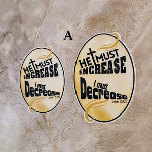 May include: Two yellow and gold round stickers with black text. The text on the stickers reads "He must increase, I must decrease, John 3:30".