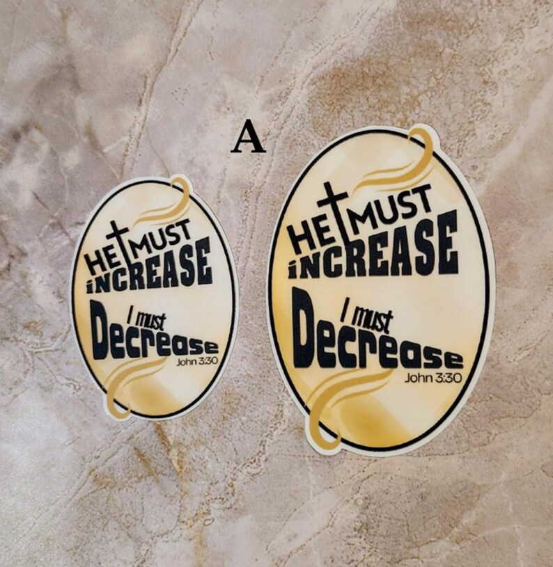 May include: Two yellow and gold round stickers with black text. The text on the stickers reads "He must increase, I must decrease, John 3:30".