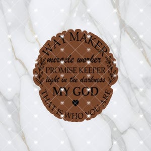May include: A brown, circular graphic with a scalloped edge, featuring the words "WAY MAKER, miracle worker, PROMISE KEEPER, light in the darkness, MY GOD, THAT IS WHO YOU ARE" in black text. A small black heart is in the center.