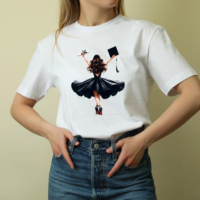 May include: White t-shirt featuring a graphic of a graduate in a black dress, holding a diploma and graduation cap. The illustration shows the graduate from the back, with flowing brown hair and red high heels. The design is centered on the shirt.