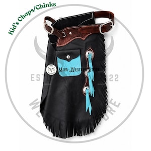 May include: Black leather chaps for children featuring a brown leather belt with silver buckles, a turquoise pocket with a snap closure, silver conchos, and turquoise leather fringe accents. The text Kid's Chaps/Chinks and Mira Western Store is visible.