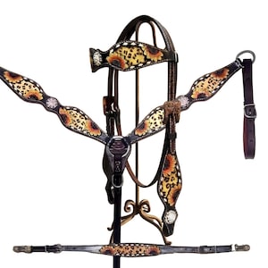 May include: A Western-style horse tack set featuring a headstall, breast collar, and other accessories. The set is made of dark brown leather and decorated with a sunflower and leopard print design. Rhinestone accents add sparkle to the floral pattern.