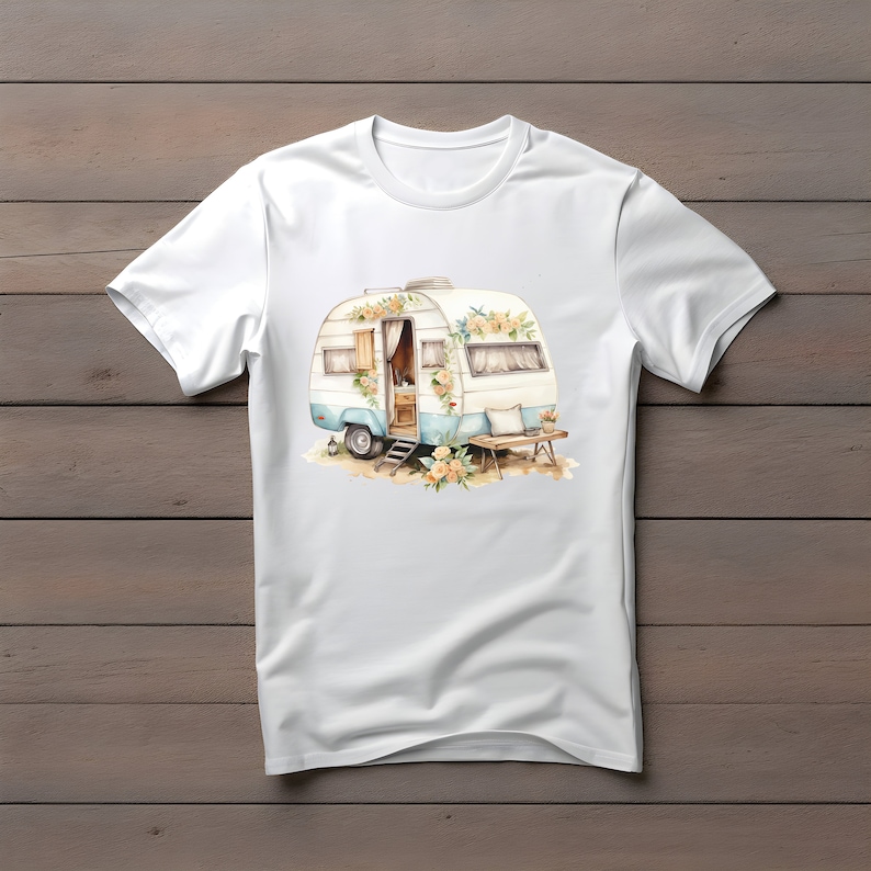 May include: White t-shirt with a watercolor illustration of a vintage camper van decorated with flowers. The camper van is blue and white with a wooden door and a small window. There is a small table and chairs in front of the camper van.