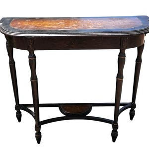 May include: A semi-circular console table featuring a dark wood frame with black painted accents. The tabletop displays an intricate inlaid wood marquetry design. The table is supported by four slender, turned legs connected by a curved stretcher.