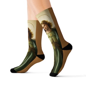 May include: A pair of socks with a colorful image of a person in a green robe with a halo. The socks are brown with black accents.