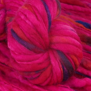 Puede incluir: Primer plano de un hilo rosa, rojo y azul con una textura peluda. El hilo está retorcido y anudado, creando una apariencia suave y esponjosa.