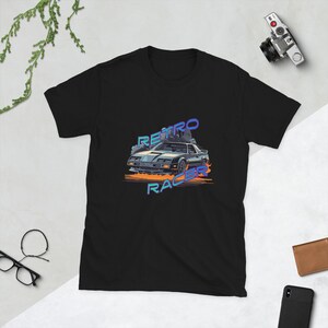 Op de afbeelding: Zwart T-shirt met een retro-grafische afbeelding van een zwarte auto met vlammen en de tekst "RETRO RACER" in blauw en paars.