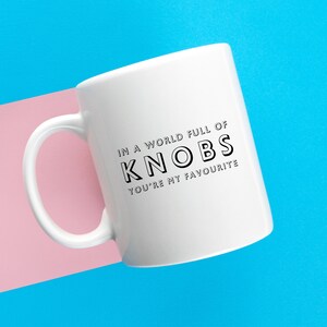 May include: White ceramic mug with a black graphic that reads "In a world full of knobs, you're my favourite."