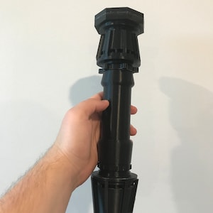 May include: A black 3D printed lightsaber hilt with a hexagonal top and a textured cylindrical body.