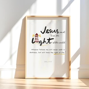 May include: A framed print featuring a lighthouse illustration and the text "Jesus said, 'I am the light of the world.'"  Whoever follows me will never walk in darkness, but will have the light of life. John 8:12