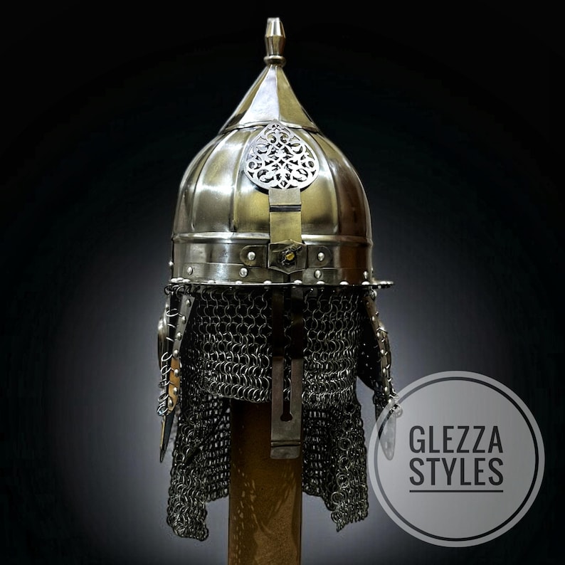 May include: A vintage-style metal helmet with a domed crown and ornate detailing. The helmet has a chainmail neck protector and a decorative central plate. The image includes the text "GLEZZA STYLES" within a circular logo.