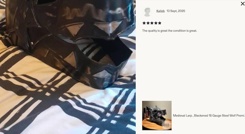 May include: A black, wolf-shaped medieval LARP helmet made of blackened 18-gauge steel. The helmet is detailed with angular features and sits on a patterned fabric. The image includes a customer review.