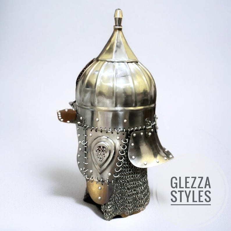 May include: A silver metal helmet with a pointed top and a rounded, ribbed crown. The helmet has a face guard, chainmail, and decorative metalwork. The text "GLEZZA STYLES" is visible on the right side.