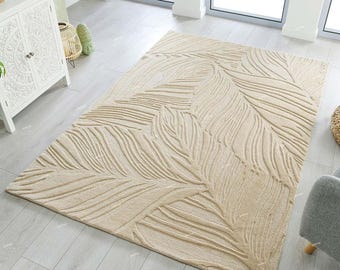 May include: A beige area rug with a raised, textured design of stylized leaves. The rug has a subtle, light brown color and a contemporary style.