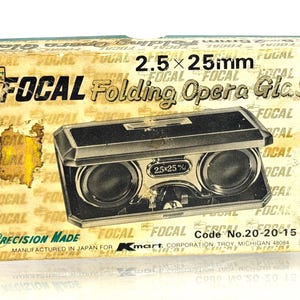 May include: Vintage Focal Folding Opera Glass in its original box. The box is tan with black text and a black and silver opera glass visible through a window. The text on the box reads "Focal Folding Opera Glass" and "Precision Made".