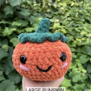 May include: A crocheted pumpkin with a green stem and a smiling face. The pumpkin is orange and has a fuzzy texture. The text "LARGE PUMPKIN PDF CROCHET PATTERN" is below the pumpkin.