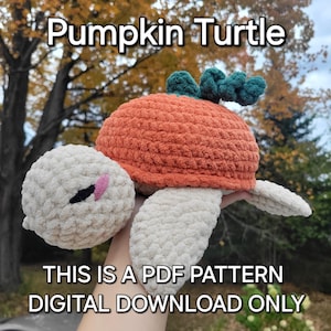 以下が含まれることがあります： かぼちゃの亀の編み物パターン。亀は白い糸でできており、かぼちゃの殻は緑色の茎が付いたオレンジ色です。画像には「Pumpkin Turtle」と「This is a PDF pattern Digital Download Only」のテキストが表示されています。