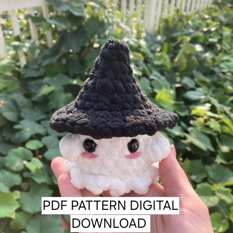 K&ouml;nnte beinhalten: Ein H&auml;kelmuster f&uuml;r ein wei&szlig;es Gespenst mit einem schwarzen Hexenhut. Das Muster ist als digitaler Download erh&auml;ltlich. PDF PATTERN DIGITAL DOWNLOAD