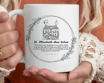 May include: White ceramic mug with a black and white illustration of a house with a quote by St. Elizabeth Ann Seton: "The first end I propose in our daily work is to do the will of God; secondly, to do it, in the manner he wills it; and thirdly to do it because it is his will."