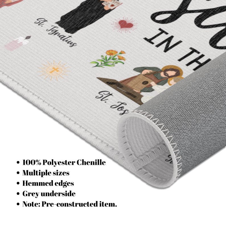 May include: A white chenille rug with a printed design featuring religious figures and text. The rug has a grey underside and hemmed edges. The text includes "St. Ignatius" and "IN TH". Made of 100% polyester chenille.