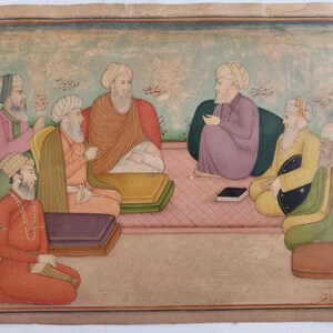 May include: An antique miniature painting depicting a gathering of seven figures in traditional attire. The figures are seated on cushions and mats, with a muted color palette of pinks, greens, and oranges. The artwork has a vintage aesthetic.