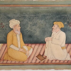 May include: An antique painting depicting two men in traditional attire seated on a striped rug. One man wears a yellow robe and turban, the other a white robe and turban. A small book rests between them. The background is a mottled green.