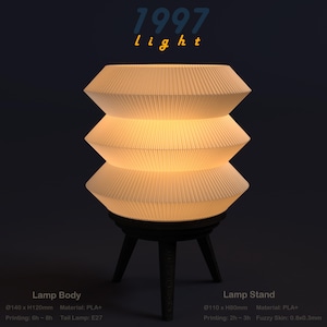 May include: A cream-coloured, layered lamp with a pleated shade, on a dark, three-legged stand. The lamp has the text "1997 light" above it. The lamp body is 140mm x 120mm, and the stand is 110mm x 80mm.