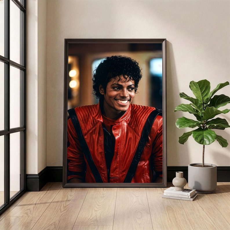 May include: Framed portrait of a smiling person wearing a red leather jacket with black stripes. The portrait is displayed on a wall next to a window and a potted plant. The room has wooden floors.