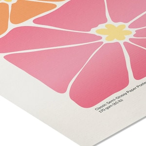 May include: A semi-glossy paper poster featuring a stylized floral design. The artwork showcases large, abstract flowers in shades of pink, orange, and yellow, with white outlines. The poster is labeled "Classic Semi-Glossy Paper Poster 170 gsm (65 lb)".