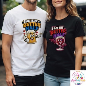 Peut inclure: Un t-shirt blanc avec une chope de bière dessinée et le texte SHE IS MY BETTER HALF et un t-shirt noir avec un verre de vin dessiné et le texte I AM THE BETTER HALF. Les deux t-shirts présentent des imprimés graphiques colorés avec des cœurs.