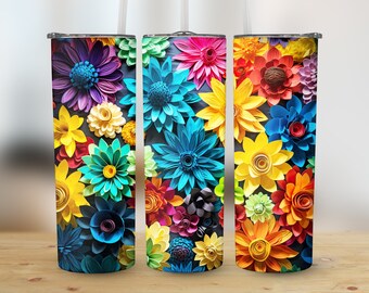 Puede incluir: Tres vasos de acero inoxidable con diseños de flores de papel de colores. Los vasos son todos del mismo tamaño y forma, pero cada uno tiene una disposición diferente de flores. Las flores son en tonos de rojo, naranja, amarillo, verde, azul y morado.