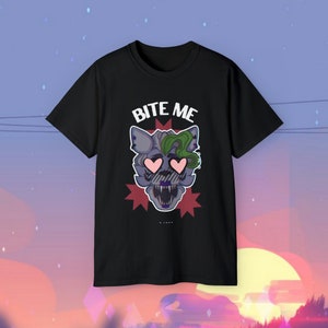 May include: Black t-shirt featuring a cartoon wolf with green hair and heart-shaped eyes. The text "BITE ME" is above the wolf.