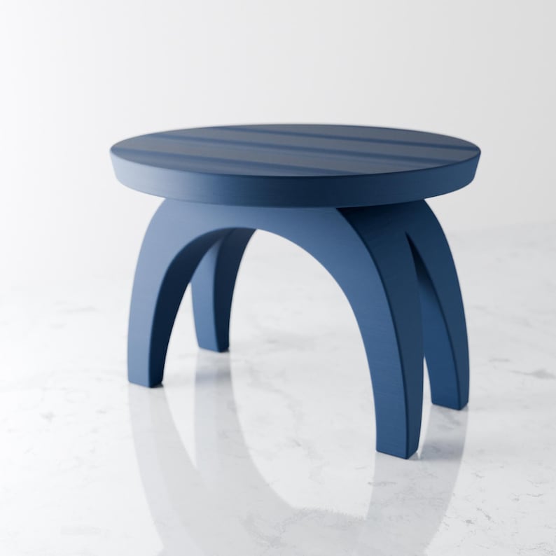 May include: A blue wooden stool with a round top and three curved legs. The top has a striped design.
