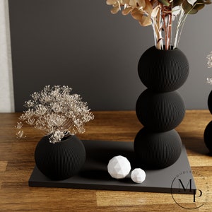 The BUBBLE Vase in Matte Black creates a sense of whimsy and joy with its enchanting design.