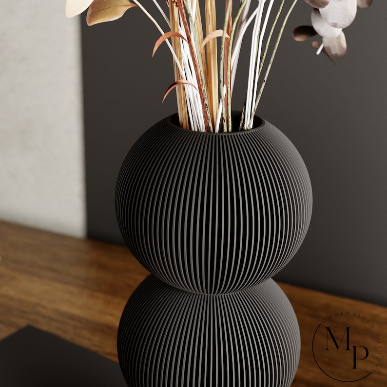 The BUBBLE Vase in Matte Black creates a sense of whimsy and joy with its enchanting design.