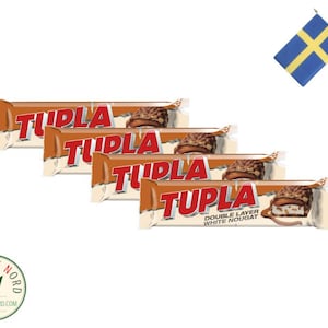 Peut inclure: Quatre barres chocolatées emballées individuellement avec le nom de la marque "TUPLA" imprimé en rouge sur le devant. Les barres sont empilées les unes sur les autres. La barre du bas porte le texte "DOUBLE LAYER WHITE NOUGAT" imprimé dessus.