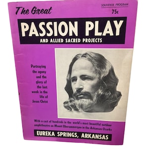 Könnte beinhalten: Ein Vintage-Souvenirprogramm für "The Great Passion Play" in Eureka Springs, Arkansas. Das Cover ist lila mit schwarz-weißem Text und einem Porträt von Jesus Christus. Das Programm ist ein Souvenir aus dem Freilufttheater.